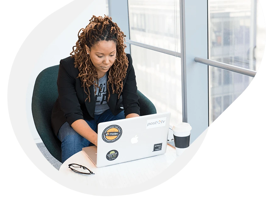 Confident woman using a laptop in a bright office