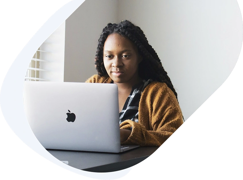 Young woman using a laptop at home to check her approval status for a $2,000 loan.