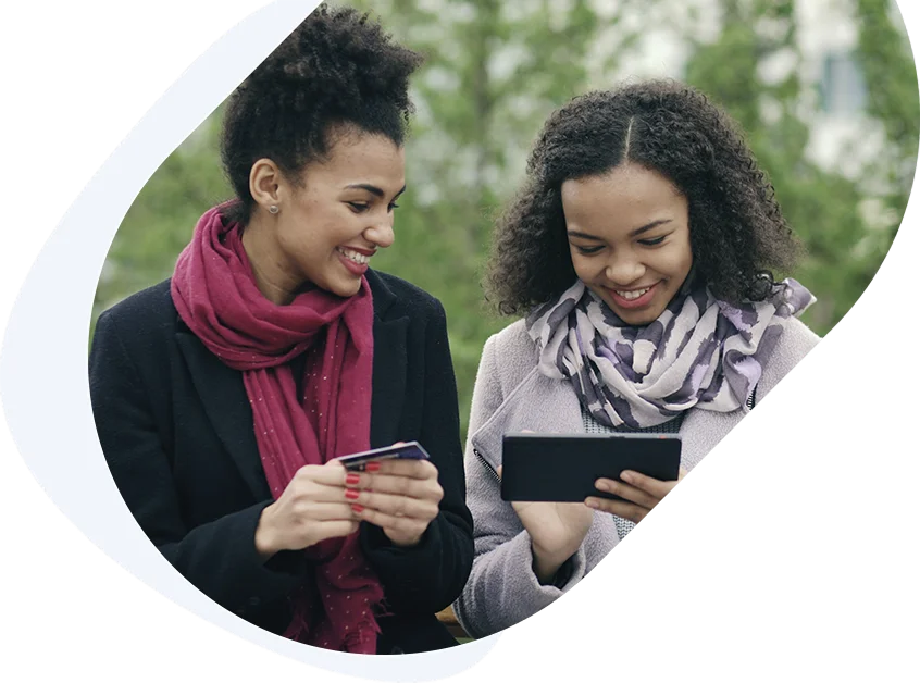 Smiling friends entering their card details to get a fast $700 loan online