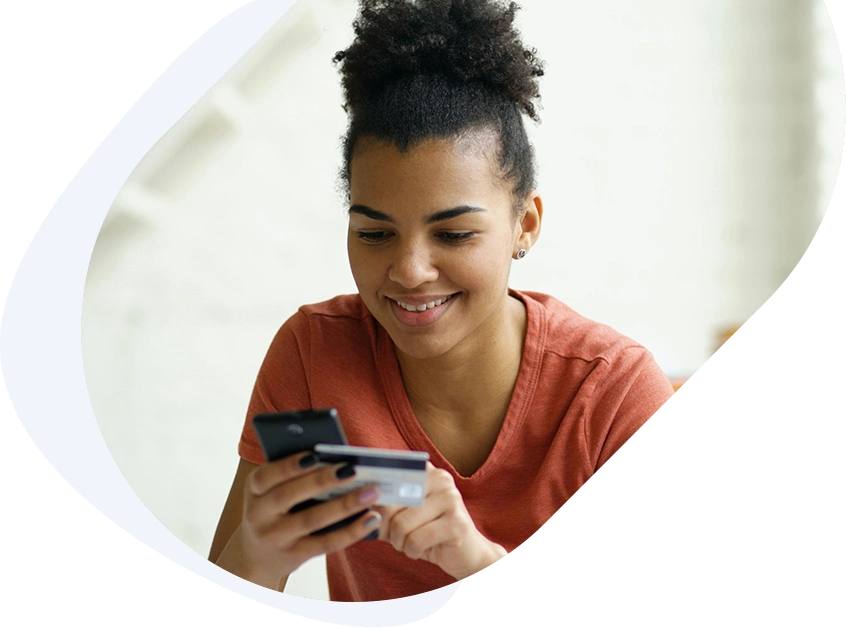 Young woman holding her phone as she applies for an emergency loan