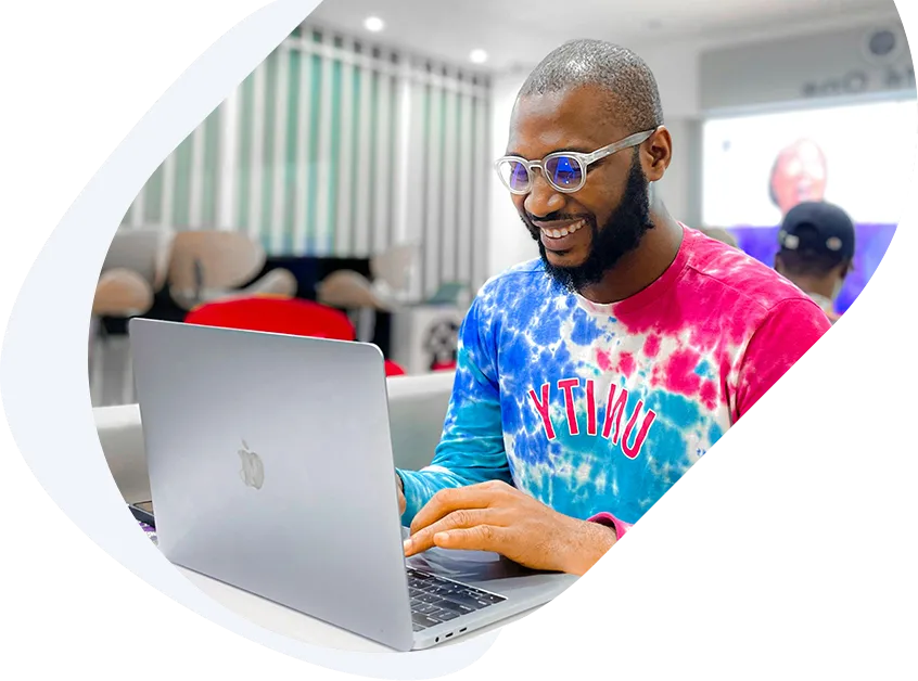 Smiling man applying for a 1-hour payday loan with no credit check on his laptop