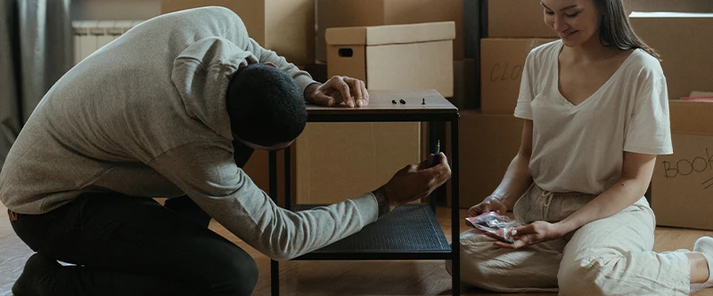 Young couple assembling a table at home, representing furniture financing options