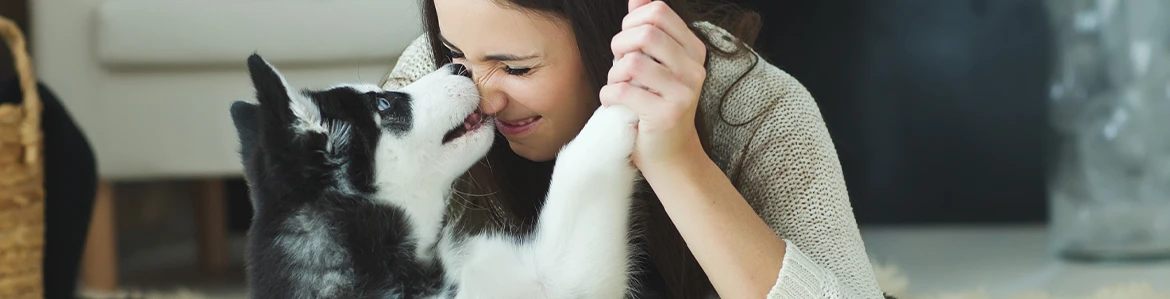 Young woman hugging her dog while planning pet financing loans for ongoing care.